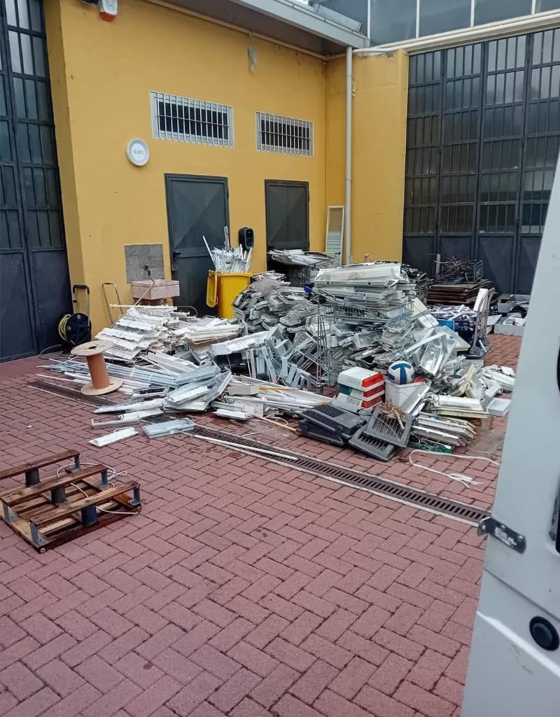 cortile industriale pieno di scarti e macerie prima